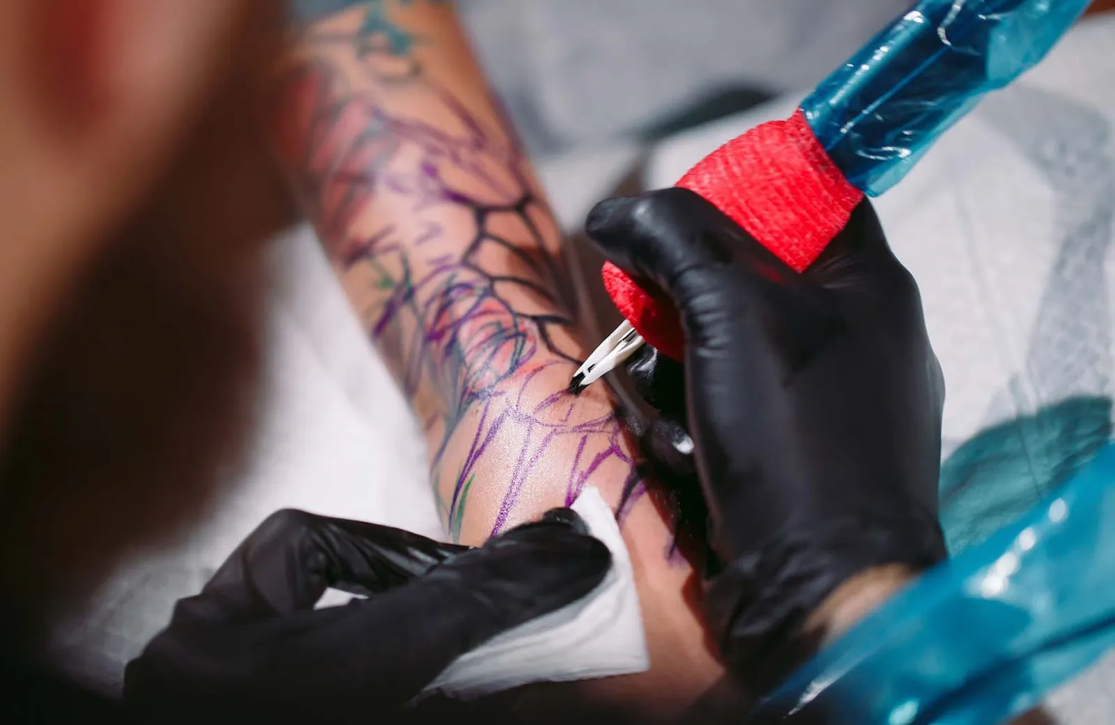 Professional tattoo artist makes a tattoo on a young girl's hand